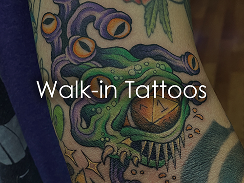 Img_Flip_Walkin Small Colorful forearm tattoo of a green sea monster with purple tentacles and orange eyes; overlaid with the words “Walk-in Tattoos.”